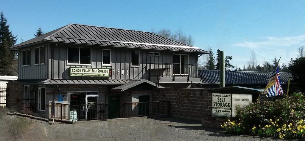A two-storey office building with peaked roof and grey siding, the home of Comox Valley Self Storage.